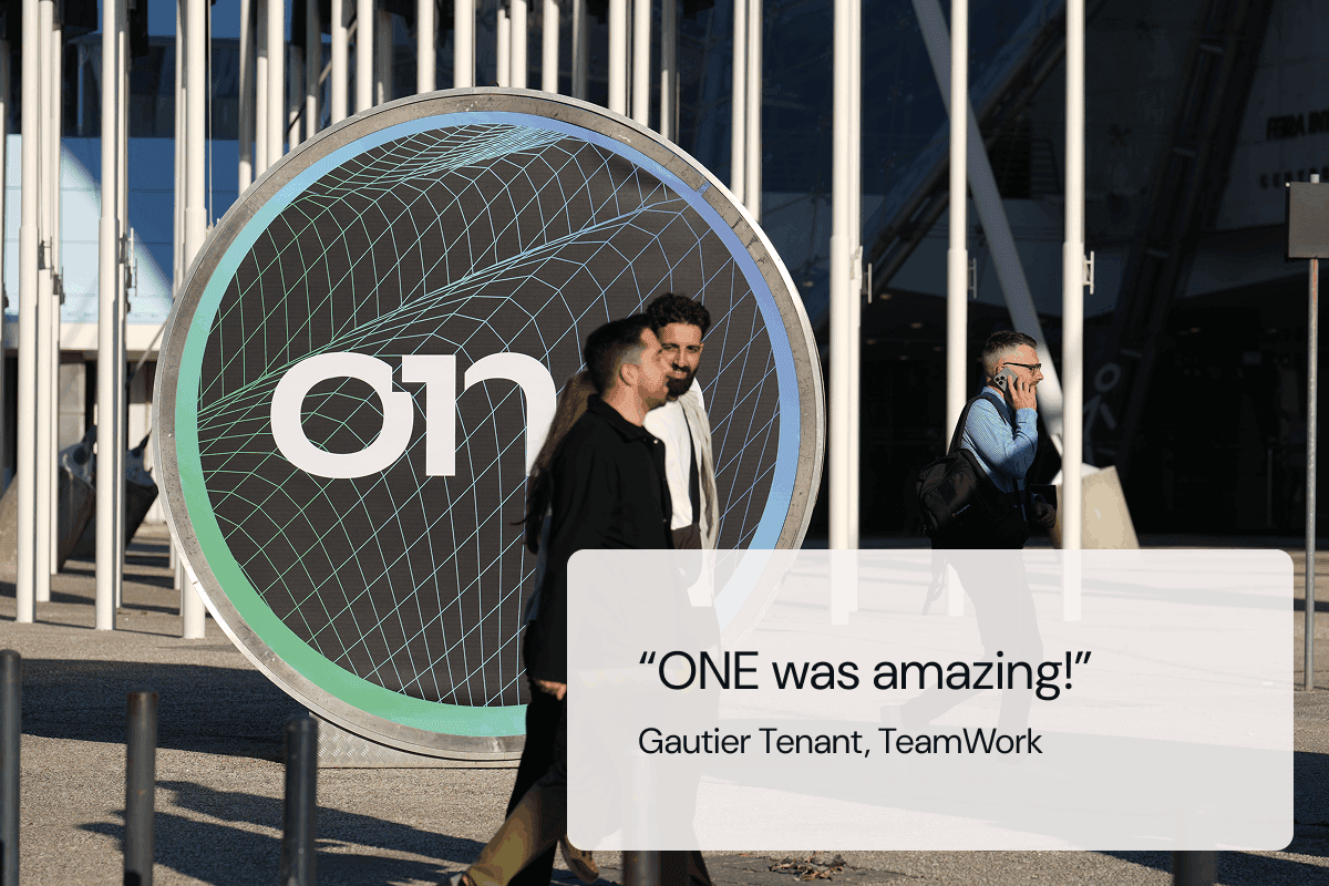 Attendees walking in front of a ONE Conference Ad